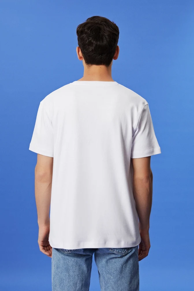 White T-shirt seen from the back on a blue studio background