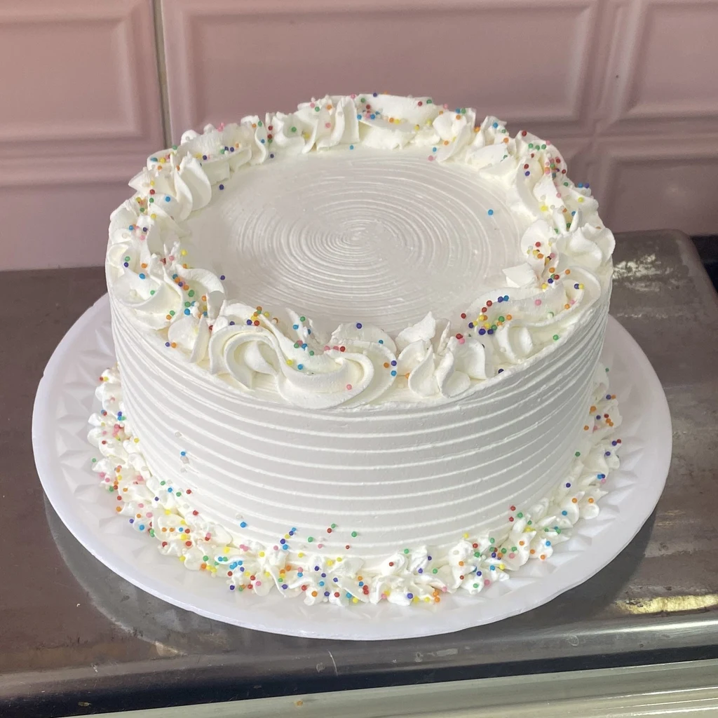 White cake with a swirled top and a sprinkle border